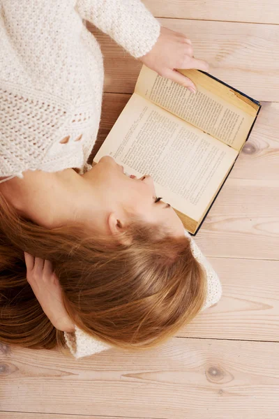 Joven hermosa mujer acostada en el suelo con libros . — Foto de Stock
