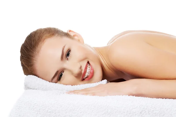 Vrouw is liggend op een massagetafel — Stockfoto