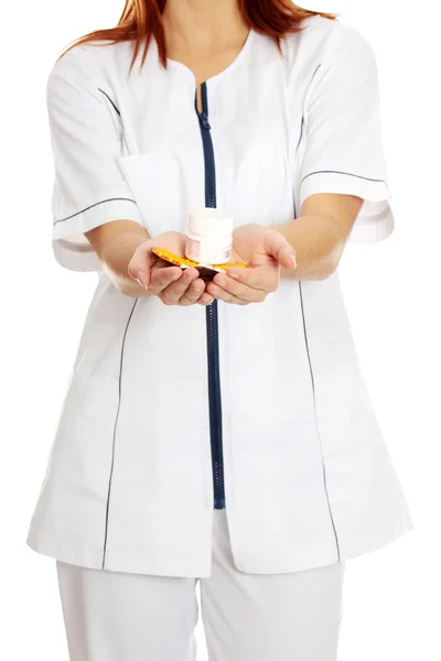 Female nurse holding pills. — Stock Photo, Image