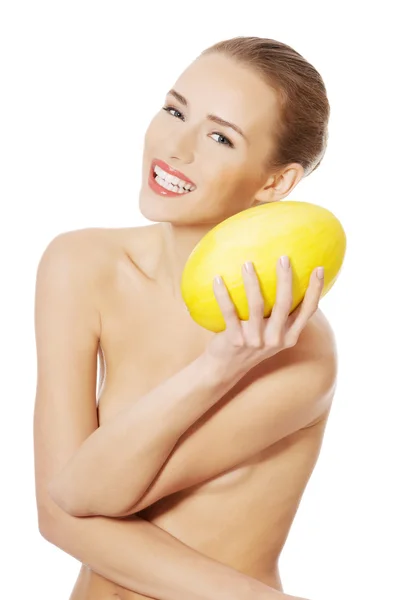 Naked woman holds yellow fresh melon. — Stock Photo, Image