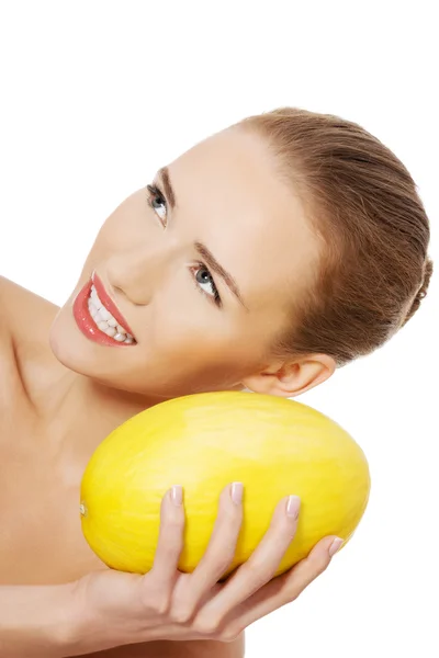 Naked woman holds yellow fresh melon. — Stock Photo, Image