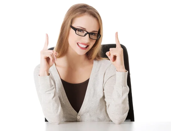 Woman sitting and pointing up, advertising — Stock Photo, Image