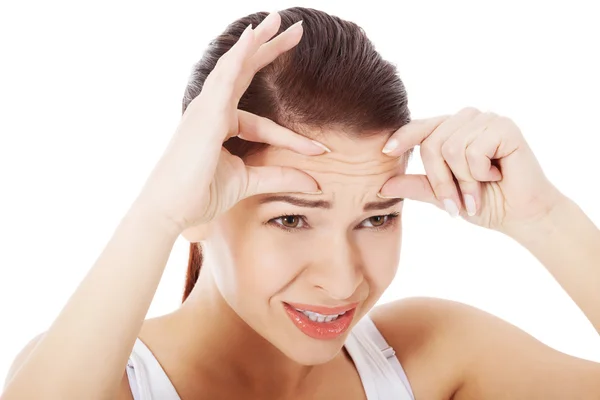 Vrouw controleren haar rimpels op het voorhoofd. — Stockfoto