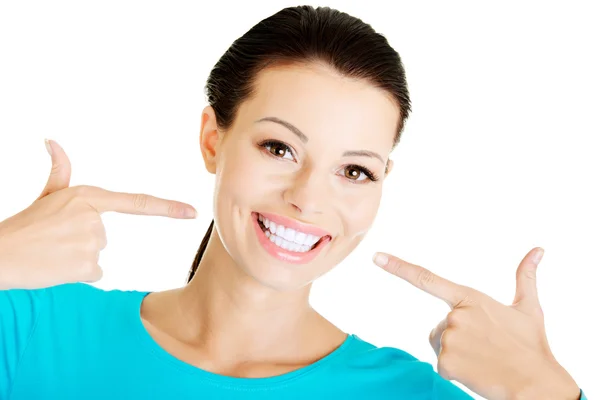 Mulher bonita apontando em seus dentes brancos perfeitos . — Fotografia de Stock