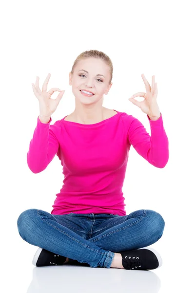 Young casual woman student showin OK gesture. — Stock Photo, Image