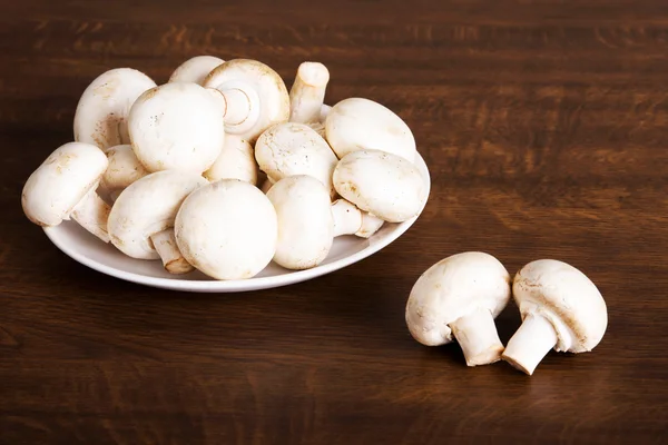 Fresh raw mashroom lying on a plate. — Stock Image Fresh raw mashroom lying on a plate. Stock Photo