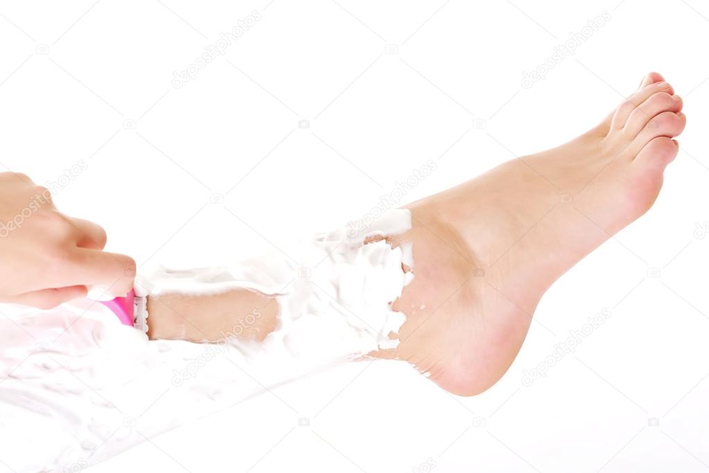 Woman is shaving her leg with razor and foam.