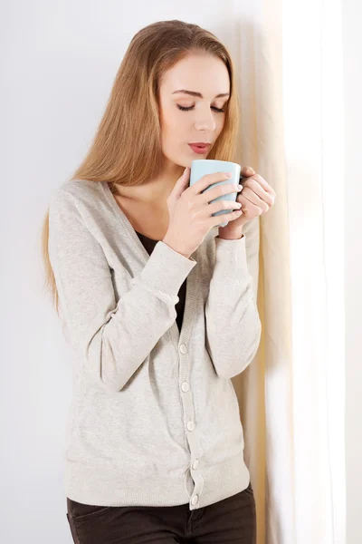 Mujer junto a la ventana con bebida — Foto de Stock