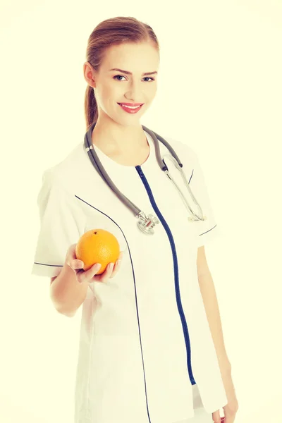 Doctor or nurse holding an orange. — Stock Photo, Image