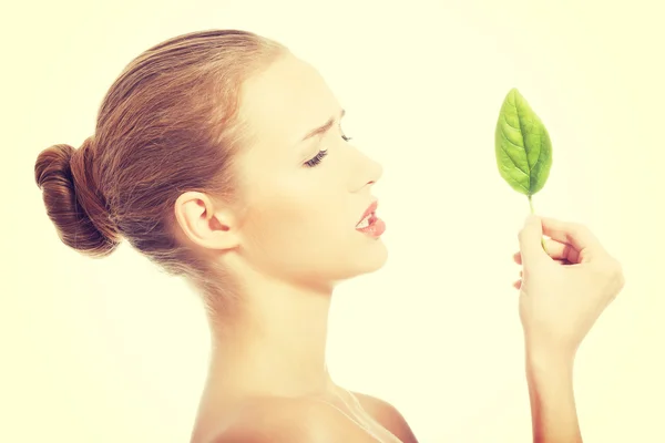 Beautiful caucasian woman eating fresh green leaf. — Stock Photo, Image