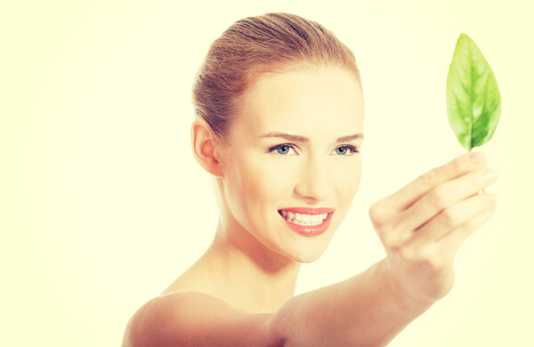 Beautiful caucasian woman eating fresh green leaf.