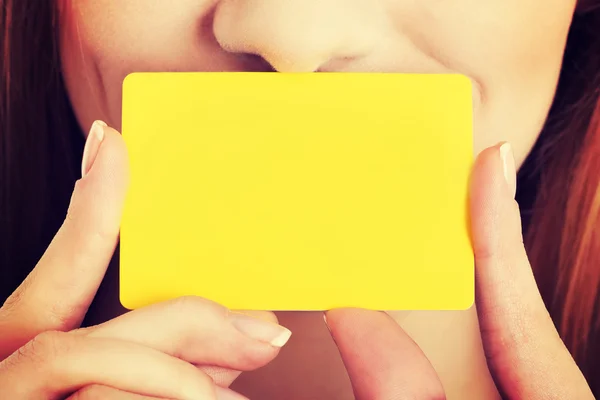 Cartão pessoal amarelo vazio sobre o rosto da mulher . — Fotografia de Stock