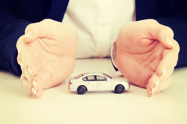Bil leksak modell mellan händerna. — Stockfoto