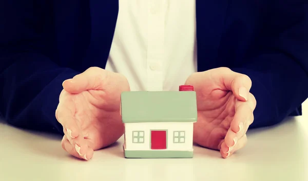 House model between hands on table. Royalty Free Stock Photos