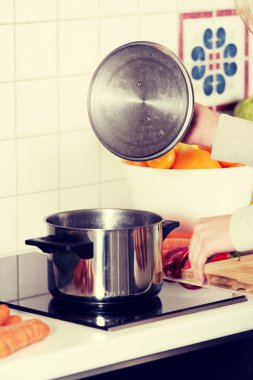 Mutfaktaki kadın yemek yapıyor..