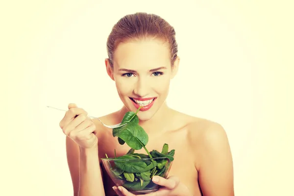 Mujer comiendo lechuga de un tazón — Foto de Stock