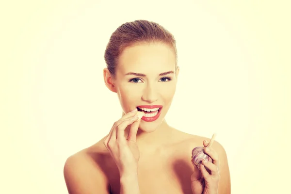 Kvinna med rå vitlök i mun. — Stockfoto