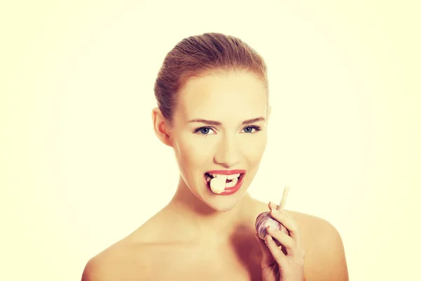 Woman with raw garlic in mouth. — Stock Photo, Image