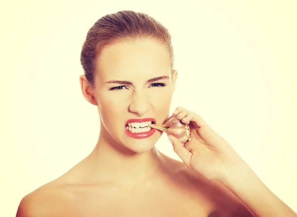 Woman with raw garlic in mouth. — Stock Photo, Image