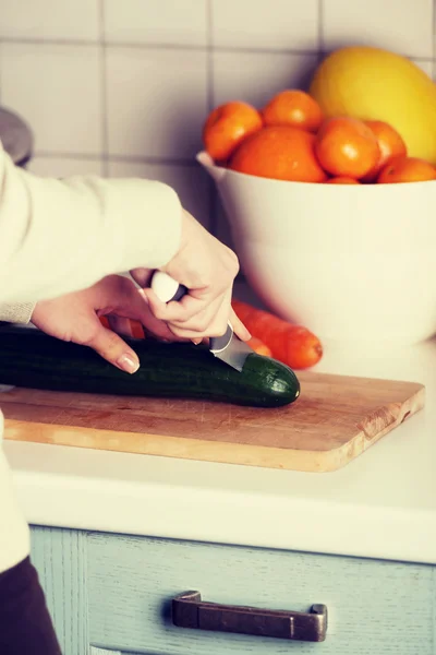 Woman is cutting cucumber. — Stock Photo, Image