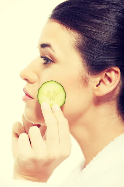 Beautiful woman holding slices of cucumber. — Stock Photo, Image