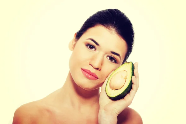 Mooie vrouwen gezicht met avocado. — Stockfoto