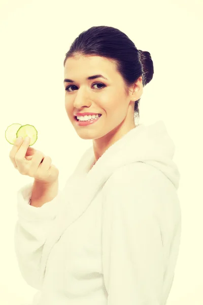 Beautiful woman in bathrobe holding cucumbers — Stock Photo, Image