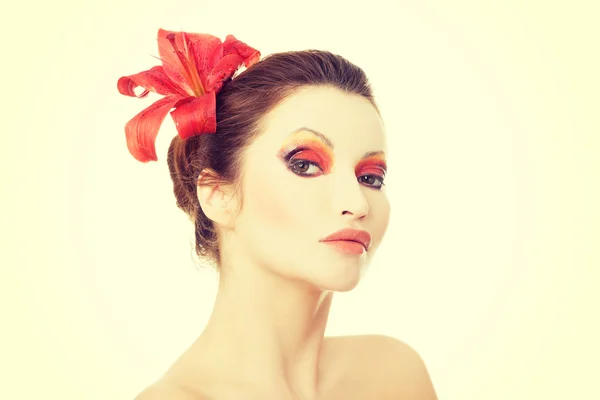 Hermosa mujer con un lirio rojo — Foto de Stock