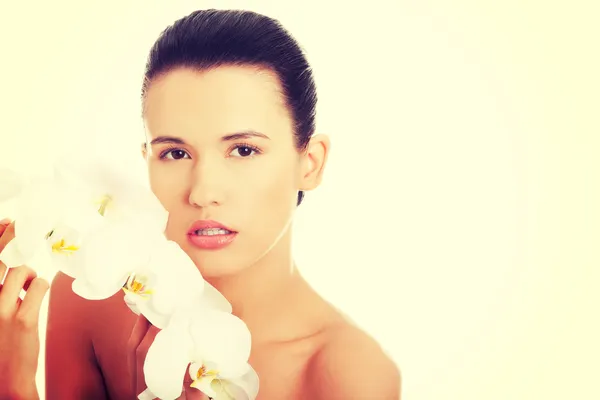 Hermosa joven con flor de orquídea — Foto de Stock