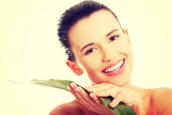 Unga vackra leende kvinna med grönt blad — Stockfoto