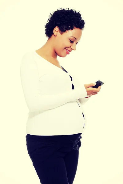 Beautiful pregnant woman dialing a number — Stock Photo, Image