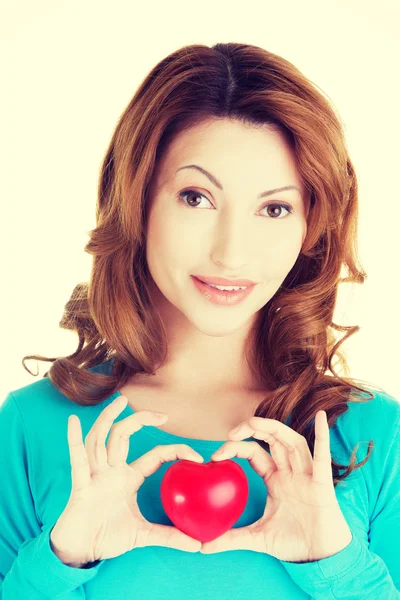 Ελκυστική χαμογελαστό γυναίκα δείχνει κόκκινη καρδιά — Φωτογραφία Αρχείου