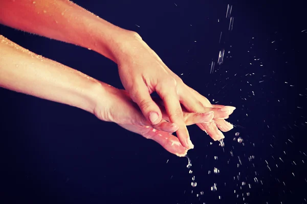 Eau tombant sur les mains féminines — Photo