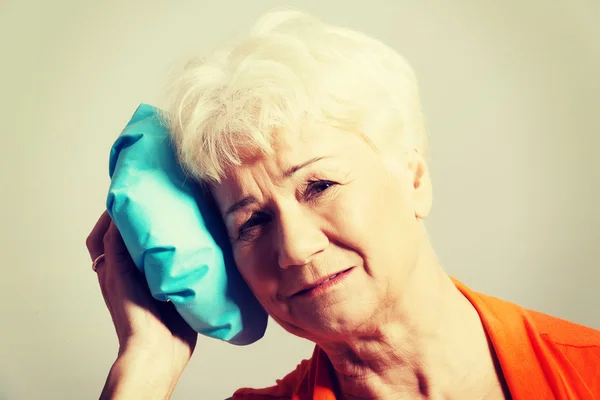 Una anciana con bolsa de hielo en la cabeza — Foto de Stock