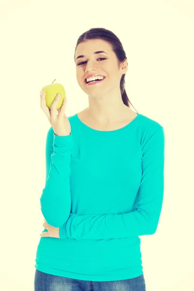 Schöne lässige Frau mit einem Apfel in der Hand. — Stockfoto