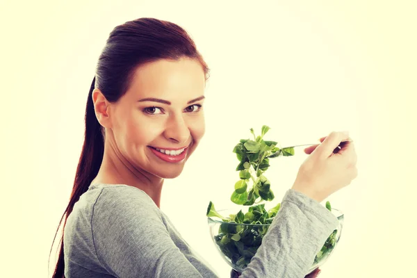Junge Gelegenheitsfrau isst Feldsalat. — Stockfoto