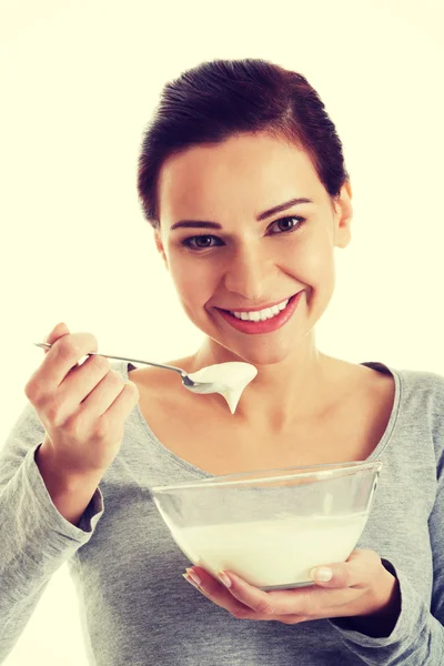 Young casual woman eating a yoghurt. — Stock Photo, Image