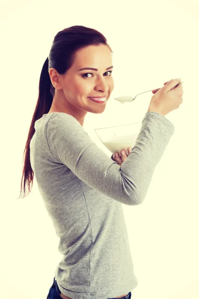 Junge Gelegenheitsfrau isst einen Joghurt. — Stockfoto