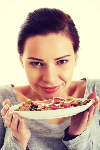 Hermosa joven con galletas en un plato . — Foto de Stock