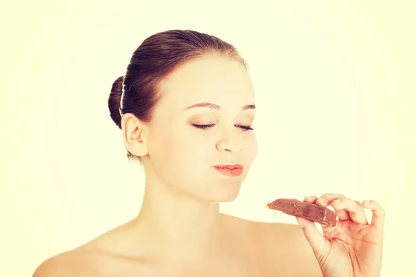 Mooie vrouw bijten een chocoladereep — Stockfoto