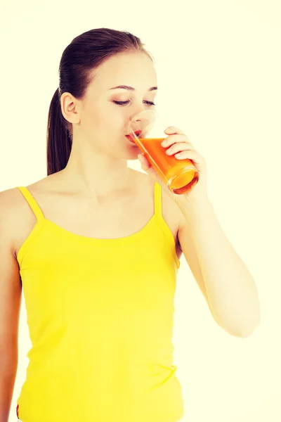 Jovem com o suco de cenoura — Fotografia de Stock