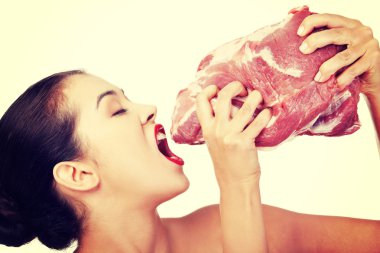 Young beautiful woman eating raw meat.