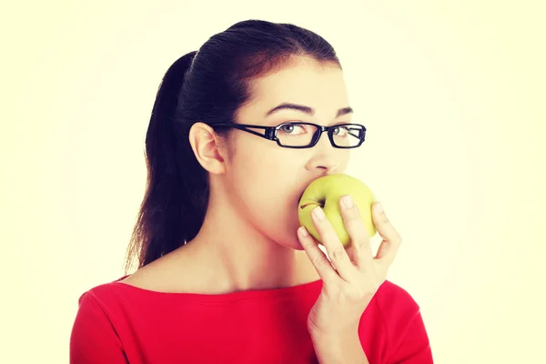 Attraktive junge Frau isst grünen Apfel. — Stockfoto