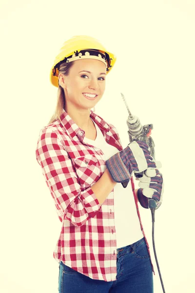 Vrouw bedrijf boor en dragen veiligheidshelm. — Stockfoto