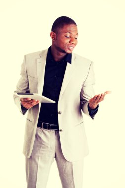 Tablet bilgisayarda çalışan yakışıklı işadamı.