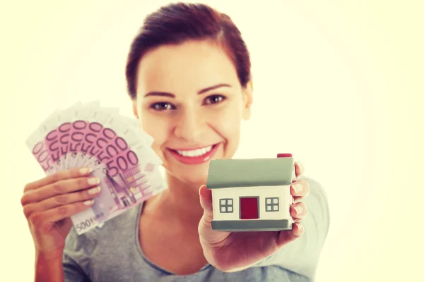 Woman holding money and house. — Stock Photo, Image