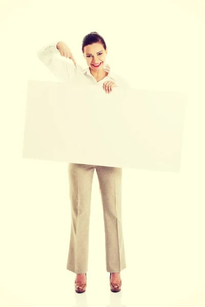 Mulher apontando em cartaz em branco — Fotografia de Stock