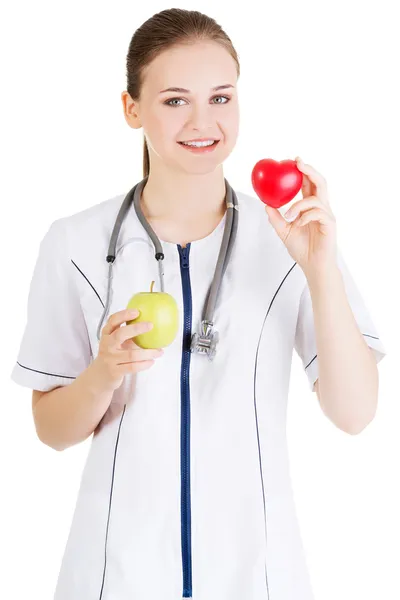 Smilingdoctor met appel en hart — Stockfoto