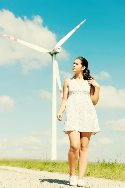 Flicka vid vindkraftverk. — Stockfoto