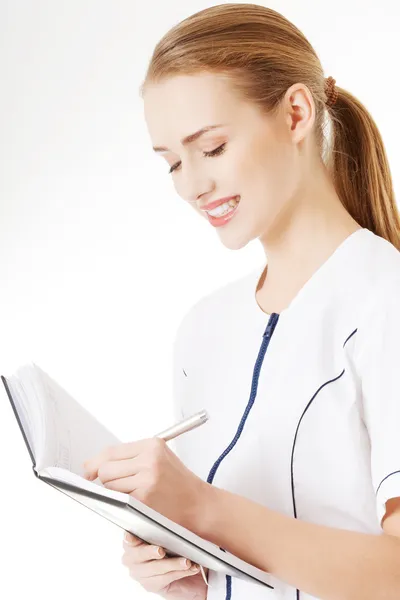 Nurse writing in notebook. — Stock Photo, Image